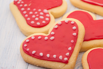 Red cookies in the shape of a heart on wooden boards close-up on Valentine's Day