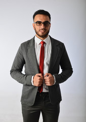 A bearded man in a business suit and red tie.
