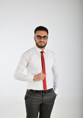 A bearded man in a business suit and red tie.
