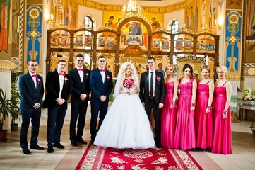 Obraz premium Stylish groomsmen and bridesmaids with wedding couple at the church