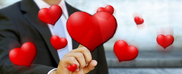 Young man touching hand drawn red heart