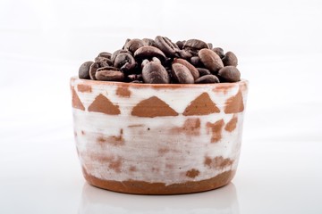 Roasted coffee beans in brown and white ceramic bowl..