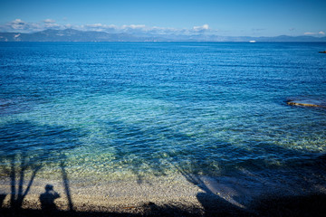 Ionian sea. shadow of man and trees on water