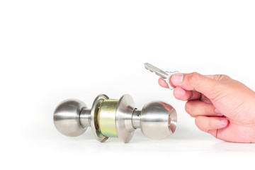Hand hold a key with stainless steel round ball door knob isolated on white background as Locksmith and industrial concept.