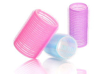 Set of three different colors and sizes hair curlers, isolated on white