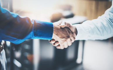 Close up view of business partnership handshake concept.Photo  two businessman handshaking process.Successful deal after great meeting.Horizontal, blurred background.