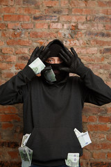 Burglar with banknotes raises hands