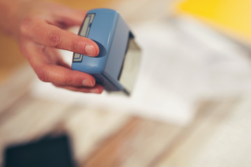 Female hand stamping document, working at office