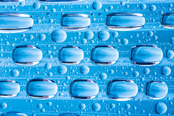Blue water drops of on treat water-repellent surface in macro lens shot small-DOF for screen...