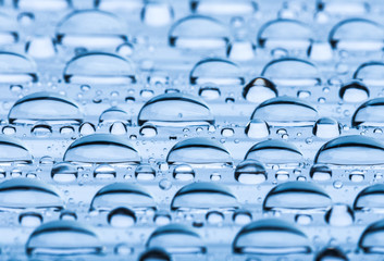 Blue water drops of on treat water-repellent surface in macro lens shot small-DOF for screen...
