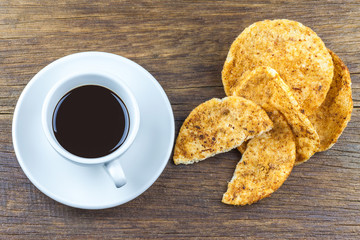 coffee and bread on wooden table.