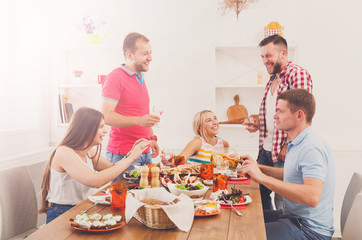 Group of happy people at festive table dinner party