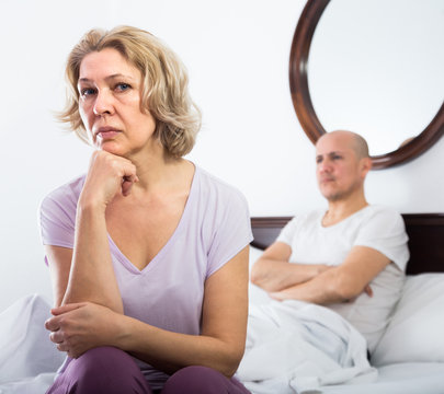 Mature couple sorting out relationships in bed.