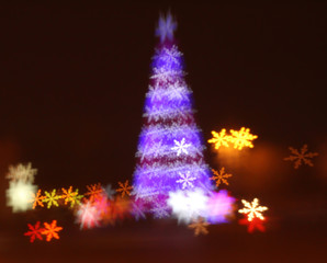 Fototapeta na wymiar Abstract christmas tree background with defocused lights of snowflakes