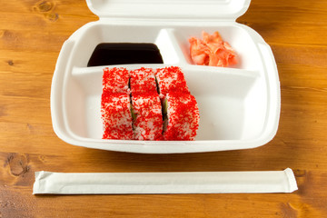California roll, soy sauce, ginger, disposable container and a s