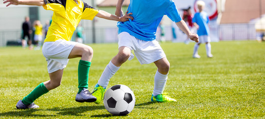 Football soccer match for children. Boys playing football game on a school tournament. Dynamic, action picture of kids competition during playing football. Sport background image.