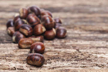 Raw chestnuts on wooden background