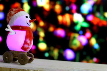 Christmas and New Year`s sale background with snowmen slides down on holiday bokeh lights. Foreground ready for product montage.Concept market banner, advertising poster with copyspace.