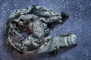Grey scarf on cement dark background. Top view with copy space