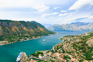Fototapeta premium Panoramic view of cityscape, old town, sea and old mediterranean port with cruise ship in Bay of Kotor, Montenegro.
