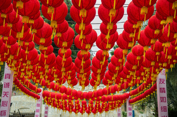 Mass of red lanterns spherical shape with yellow tassels hanging above the passage (Singapore)