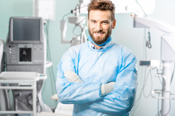 Portrait of surgeon in the operating room with surgical microscope on the background