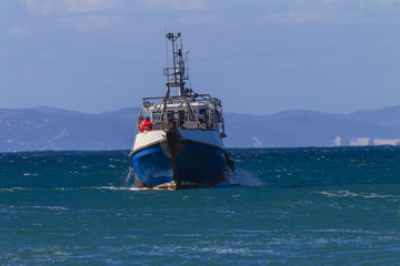 Fishing Trawler boat close inside coastline bay for ocean storm protection.