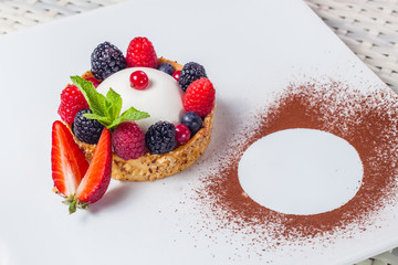 Sweet dessert. Cake with berries and strawberries on a white plate