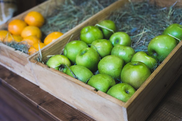 Wooden box with fresh green apples on display in a fruit shop