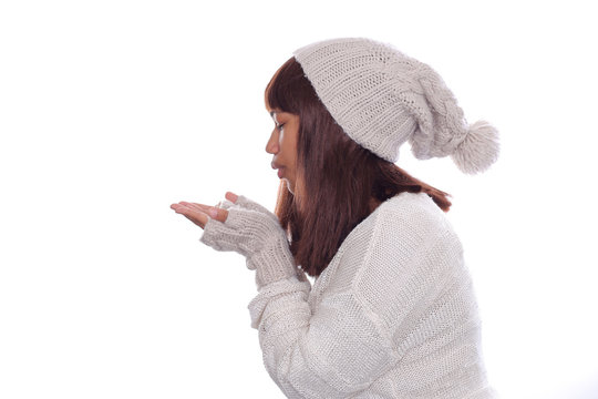 Attraktive, farbige Frau in Winterkleidung gibt einen Luftkuss