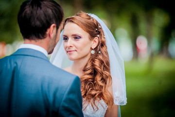 Fototapeta premium Bride and Groom at wedding Day walking Outdoors on spring nature. Bridal couple, Happy Newlywed woman and man embracing in green park. Loving wedding couple outdoor.