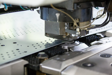 Rotation CNC Punching & Nibbling Machine in action. Metal perforating industrial machine.