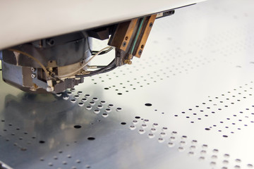 Rotation CNC Punching & Nibbling Machine in action. Metal perforating industrial machine.
