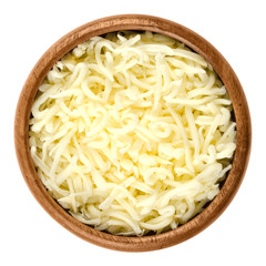 Shredded mozzarella pizza cheese in wooden bowl over white. Cheddar like semi hard Italian cheese...