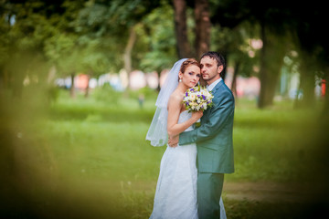 Elegant bride and groom posing together outdoors on a wedding day