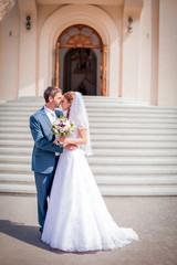 amazing bride and her groom standing near the church