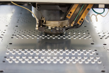 Rotation CNC Punching & Nibbling Machine in action. Metal perforating industrial machine.
