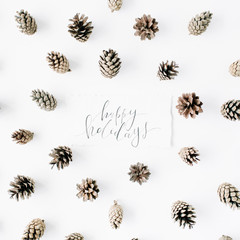 words happy holidays and minimal creative cone arrangement pattern on white. flat lay, top view. christmas background wallpaper.