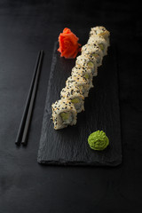 Sushi Roll with avocado,tofu and sesame on a blackboard.