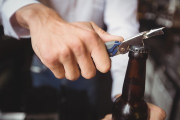 Close-up of bartender opening a beer bottle