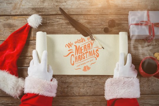 Composite image of close-up of santa claus opening scroll