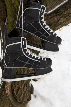 Men's hockey skates and the puck on a snowy background