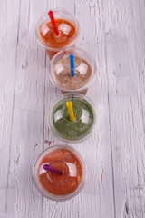 Four colorful, useful and healthy smoothies in plastic cups