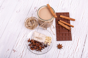 brown detox coctail with cinnamon sticks and chocolate lie on th