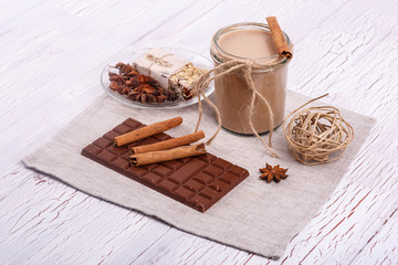 brown detox coctail with cinnamon sticks and chocolate lie on th