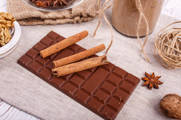 cinnamon sticks lies on bar of brown chocolate