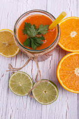 orange detox coctail with half orange and lime lies on table