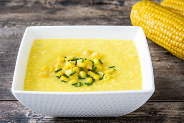 Corn soup in bowl on wooden background
