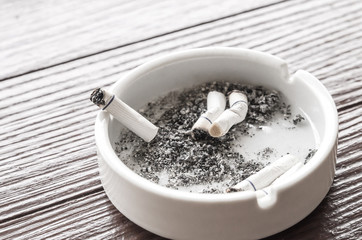 burned cigarettes is in white ashtray