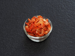 Dried shrimp, prawn in a glass bowl isolated on dark background